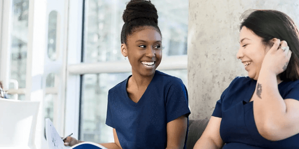 Two Nurses Looking at each other smiling