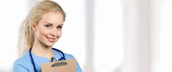 Young nurse working on laptop at home