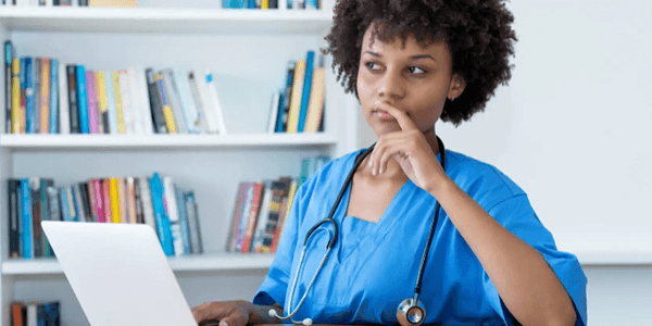Nurse on laptop top thinking
