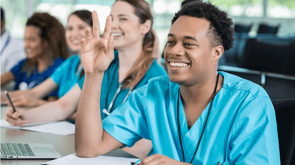 Nursing Students Smiling in Class raising their hand
